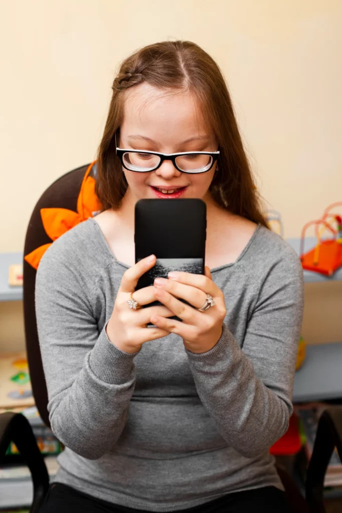 Imagen de persona con síndrome de Down consultando el teléfono.